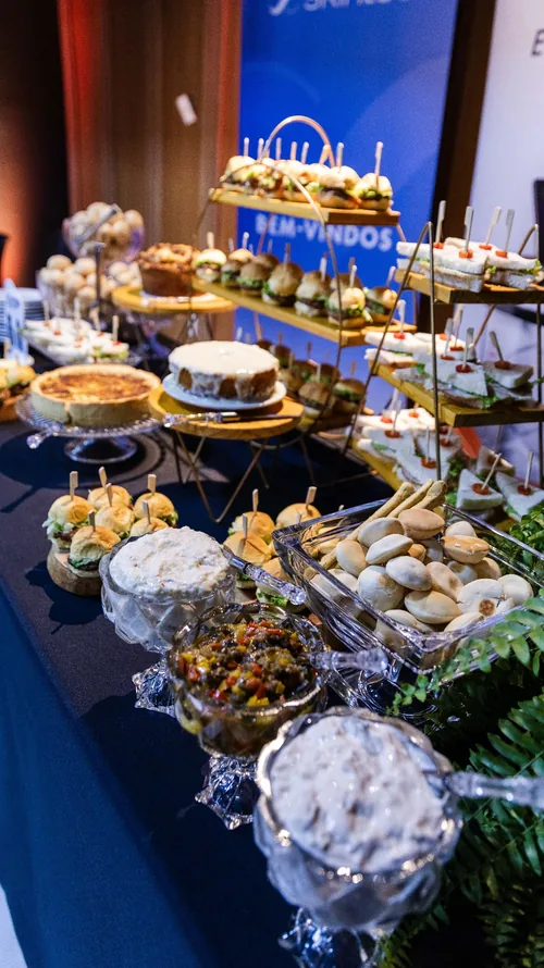 Mesa de coffee break do evento na Casa do Relacional com salgados, doces e tortas